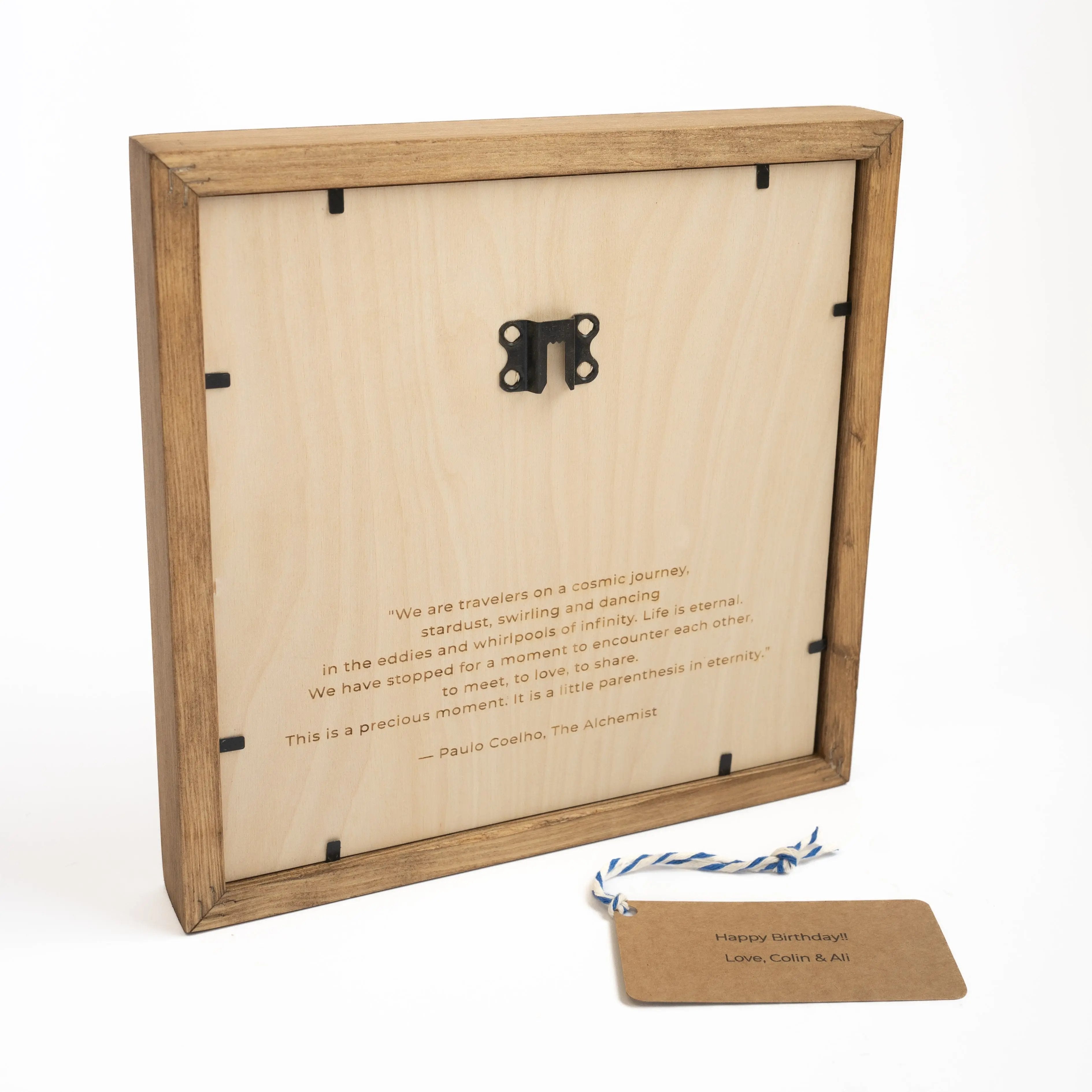 Back view of a custom wooden map with a hanging hook, engraved quote, and a personalized gift tag for a thoughtful touch.